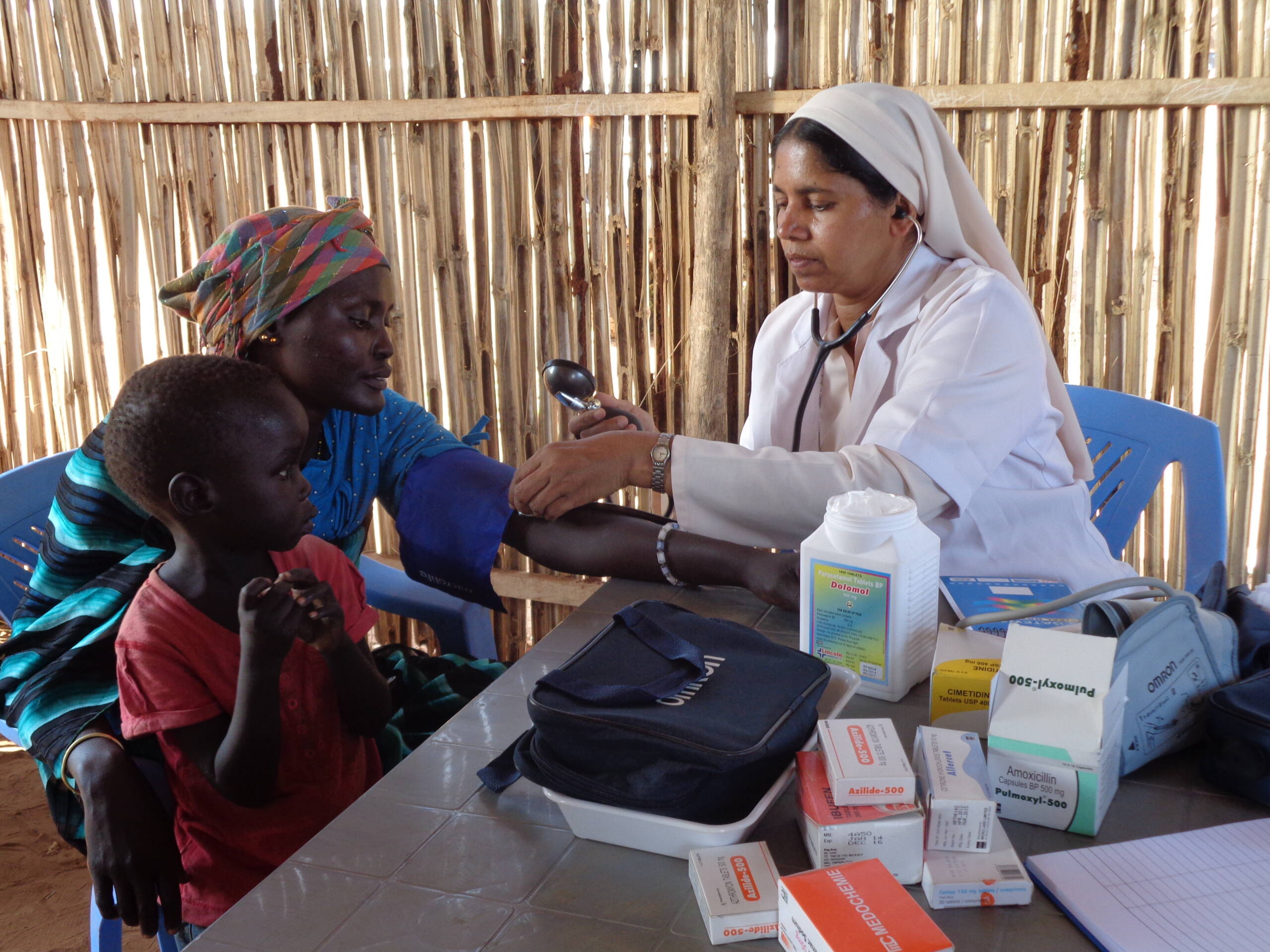 DMI nurse helping a woman and child